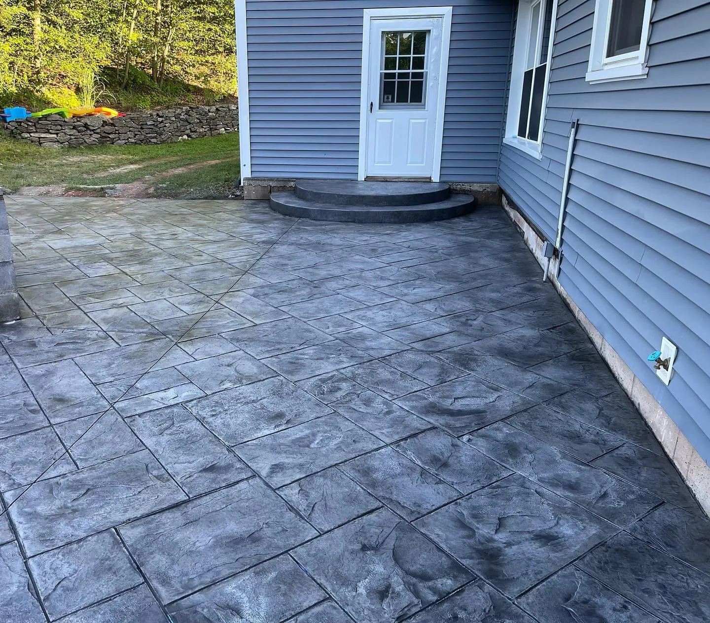 Stamped concrete patio with curved steps in Connecticut